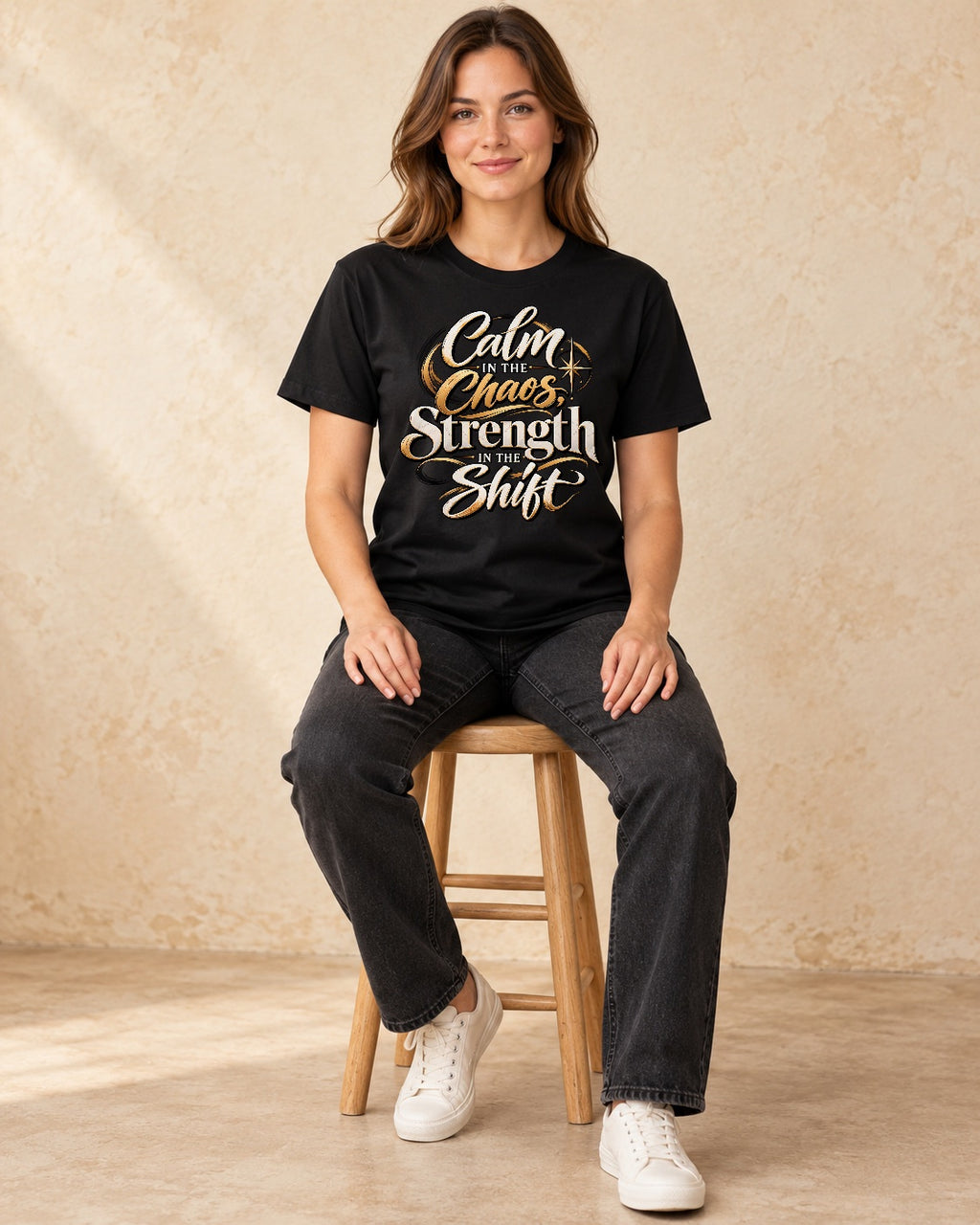 Model seated Calm In The Chaos Srength In The Shift T-shirt in Black