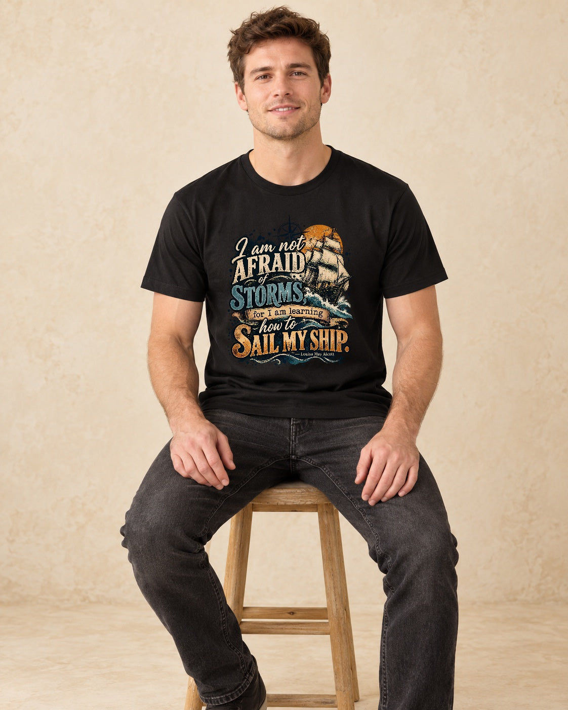 Model seated  I Am Not Afraid Of Storms For I Am Learning How To Sail My Ship T-shirt in Black