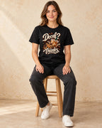Model seated Decaf No Thanks T-shirt in Black